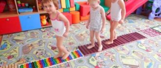 Дети идут по разноцветным массажным коврикам