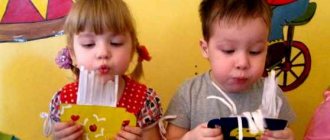 Boy and girl blowing on paper crafts